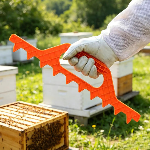 Beekeeping Frame Spacers 2 Pack 9 Frame Spacer Tool For Beehive Boxes, orange tool in gloved hand, beehives in background.