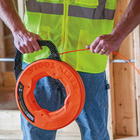 Person using Non Conductive Electrical Fish Tape With Multi Groove Fiberglass Wire Puller Nylon Tip And Pro Grade Housing And Handle