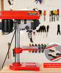 Side view of 8 Inch Benchtop Drill Press With Laser Guide And 1W LED Work Light Five Speed Settings From 620 To 3100 RPM 0 To 45 Degree Tilting Table A Beast For Wood And Metal Projects And DIY in a workshop setting with tools on the wall.