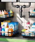 Top Tier Double Slide Out Under Sink Organizers Two Pack Black Steel Pull Out Shelves With Splash Resistant Mat Straight Up Kitchen Cabinet Organization Solution with cleaning supplies in baskets.