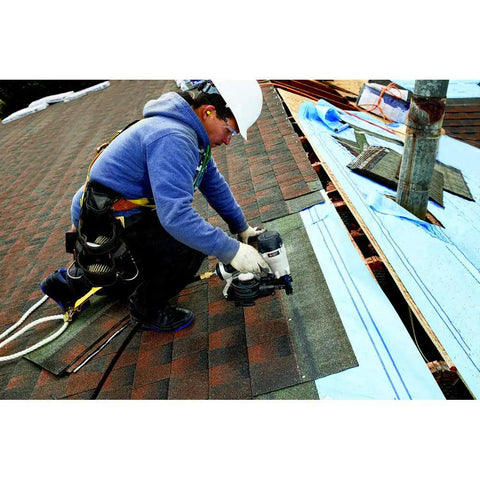 Professional using RN175C 15-Degree Pneumatic Coil Roofing Nailer for quick roofing installations on rooftop.