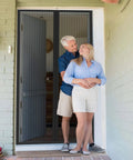 Couple enjoying fresh air with Breezy Magnetic Door Screen with Self Sealing Closure, pet and kid friendly, fits doors up to 38x82 inches