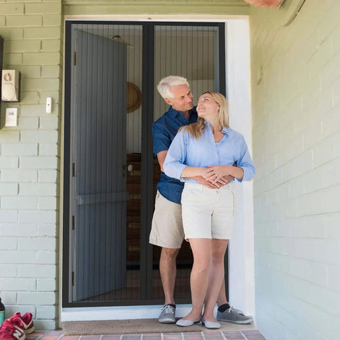 Couple enjoying fresh air with Breezy Magnetic Door Screen with Self Sealing Closure, pet and kid friendly, fits doors up to 38x82 inches