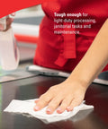 Hand using GeneralClean L30 Cloths Heavy Duty Cleaning Wipes Bulk White Wipers For Light To Medium Duty Cleanup on counter.