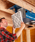 Man installing a filter in a Compact Ceiling Air Filtration Unit With Heavy Duty Triple Stage Filters for Tight Garages.
