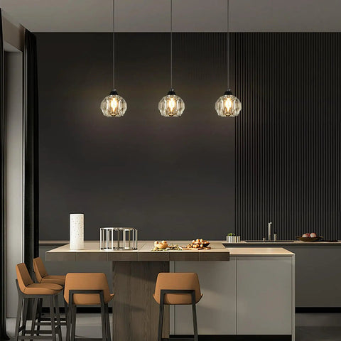 Three Light Matte Black Pendant Lighting With Transparent Glass Shades above kitchen island, industrial retro design.
