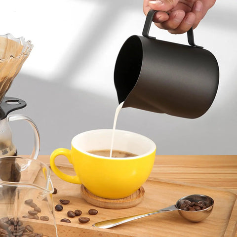 20 Oz Milk Frother Pitcher For Espresso And Latte Art Pen For Foam Stainless Steel Steaming Cup With Nonstick Coating Black Coffee Frothing Cup For Cappuccino And Milk Foam pouring milk into yellow cup