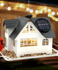 Heavy Duty Metal Outdoor Bird Feeder With Solar Lights, house-shaped feeder with seeds, solar panel on roof, hanging in garden.