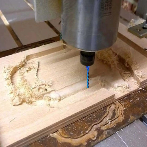 Blue-coated 3-flute carbide CNC router bit, 1/8 in diameter, 1/4 in shank, installed in spindle cutting wood.