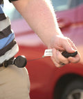 Person using Retractable Carabiner Keychain With 36 Inch Cord, Built Tough As Nails, attached to belt, holding keys towards car.