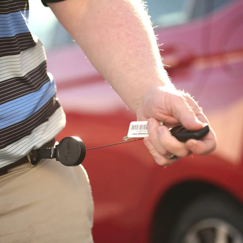 Person using Retractable Carabiner Keychain With 36 Inch Cord, Built Tough As Nails, attached to belt, holding keys towards car.