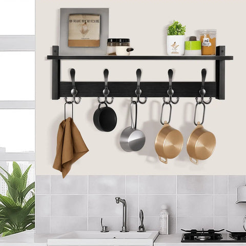 Coat Rack With Shelf And Tri Hooks Wall Mounted 24 Inch Wooden Hanging Coat Hanger For Entryway Bathroom Mudroom And Bedroom Black Finish With Stable Iron Frame For Everyday Use in a kitchen setting with pots and a towel hanging.