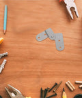 Six Piece Heavy Duty Folding Hinge Set for attic ladders and table legs on wooden surface with tools and screws visible
