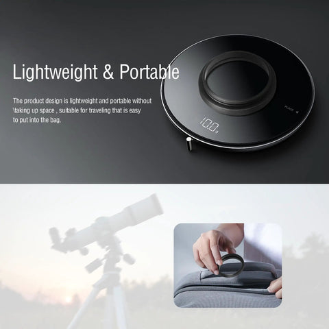 Round portable wireless charger on surface, telescope in background and hand inserting charger into bag showing its compact design.
