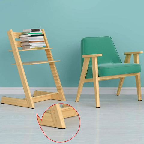 Modern wooden book holder beside a green armchair against a teal wall, showcasing functional design and style.