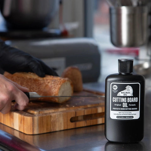 Cutting Board Oil And Wood Butcher Block Oil 128 Oz One Gallon Jug Brewed In USA With FDA Food Contact Safe Ingredients A True Kitchen Workhorse For Cutting Boards Spoons And Countertops Black Finish next to sliced bread on wooden board