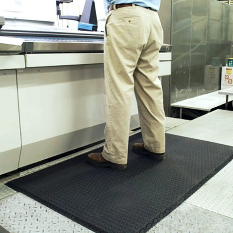 Person standing on Built Different And Tough As Nails Anti Fatigue Mat With Heavy Duty Diamond Texture in a workshop setting.
