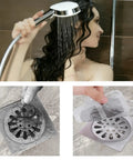 100 Pcs Disposable Shower Drain Hair Catchers Mesh Adhesive Covers Snags Human And Pet Hair Stops Clogs Dead In Its Tracks A Legit Game Changer Peel And Stick Bathroom Essential in use with water visible in shower.