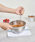 Person using Stainless Steel Ball Whisk With Silicone Tips 10.5 Inch 24 Pack in mixing bowl on kitchen counter