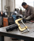 Dope Heavy Duty Grounding Clamp With Screw For Welders And Workshops featuring brass body on a workbench in a workshop.