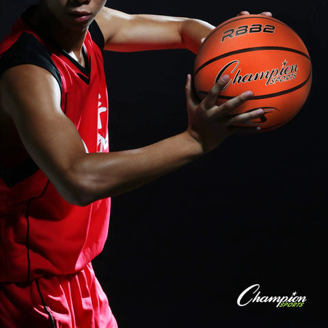 Athlete holding a basketball, showing Size 5 Pink Rubber Junior Basketball For Indoor Outdoor Play Heavy Duty Pro Style Ball.
