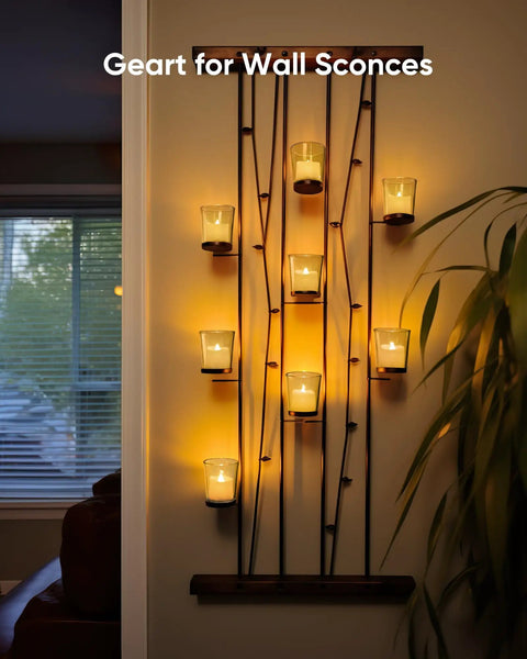 Wall sconce with 24 Pack Flameless Votive Candles Tealights Warm White Ivory Base Christmas Decor illuminating a room.