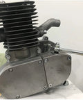 Gas engine cylinder for 2-stroke bicycle engine; aluminum-gray with cooling fins, side view showing exhaust bolts.