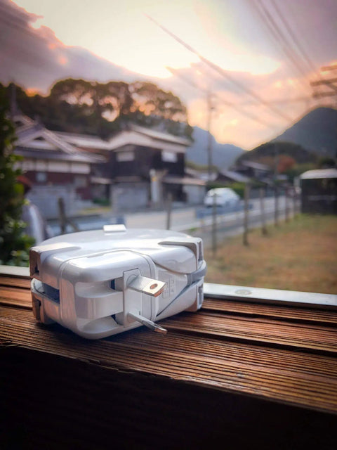 Power Station Traveler Bundle With Universal Travel Adapter, USB Charger, Power Strip on windowsill with scenic background