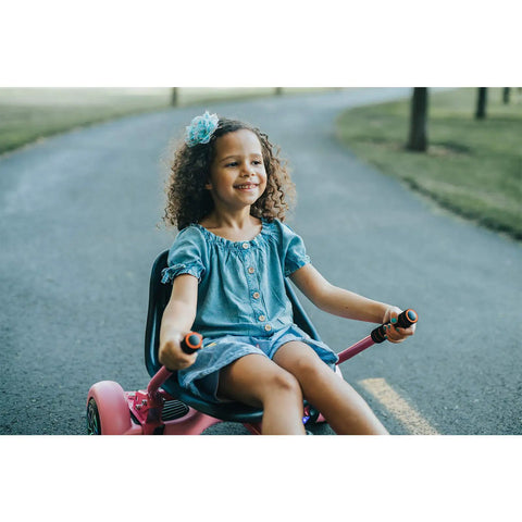 Child enjoying a ride on a pink hoverboard seat attachment for kids and grownups, go kart attachment for self balancing scooters.