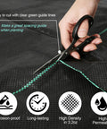 Cutting Heavy Duty Weed Barrier Landscape Fabric 4 Ft by 100 Ft 3.2 Oz Woven Geotextile Mat with scissors on green guide lines