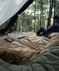 Ultralight Sleeping Quilt For Backpacking And Hammock Camping, 40 Degree Warmth With Footbox, seen inside a tent with trees outside.