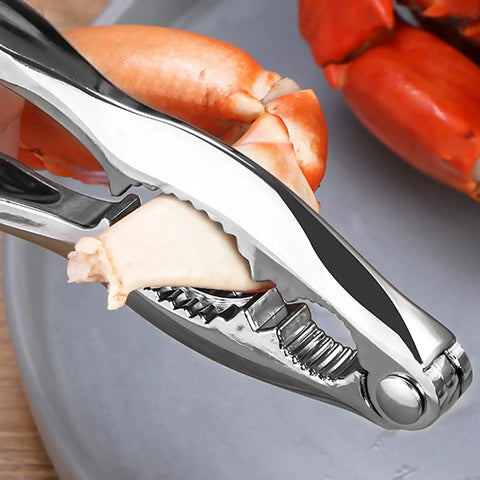 Complete 21 Piece Seafood Tools Set With Six Crab Crackers holding crab claw on grey plate