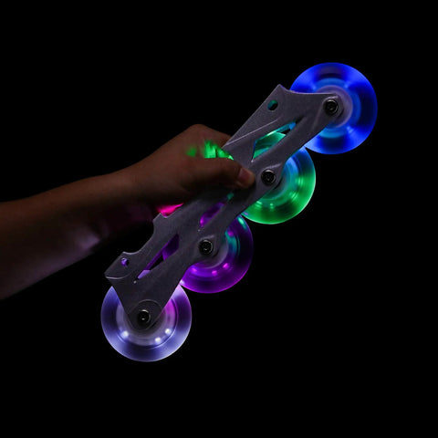 Hand holding Glowrider 92A Inline Skate Wheels with built-in magnetic LED lights, 80mm 2 pack, UV purple glow, no battery needed.