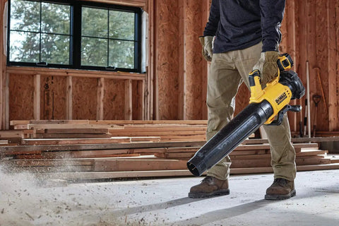 Person using DCBL722BR 20V Max XR Brushless Cordless Handheld Blower Tool Only Renewed for quick cleanups in a workshop setting.
