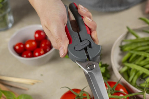 Versatile Kitchen Shears For Every Task With Micro Serrated Self Sharpening Stainless Steel Blades, in use cutting tomatoes