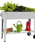 Raised Garden Bed Outdoor Planter Box On Wheels With Sturdy Legs For Vegetables Flowers Tomatoes And Herbs Patio Backyard Heavy Duty 400 Lbs Rustproof Powder Coated Steel Easily Movable Space Saving Garden System with green plants.