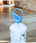 Close-up of blue ergonomic Gallon Water Bottle Handles 4 Pack Ergonomic Water Jug Lifters Carrier To Haul Heavy 5 Gallon Bottles Easy Transport For Home Office Stations And Everyday Use on top of a gallon bottle indoors.