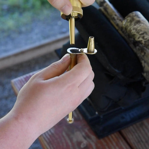 Person adjusting Adjustable Brass Powder Measure For Muzzleloading With Static Free Construction and Swivel Funnel for black powder
