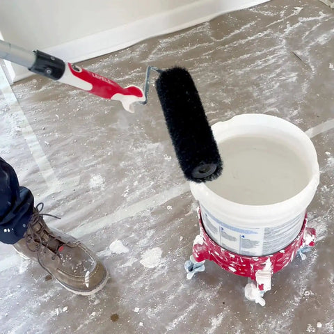 9 Inch Drywall Compound Roller For Taped Seams And Skim Prep being used on a construction floor with bucket and roller extension.
