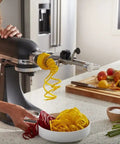 Woman using Fruit And Vegetable Spiralizer Attachment For Stand Mixer Power Hub With 5 Quick Change Blades to spiralize vegetables
