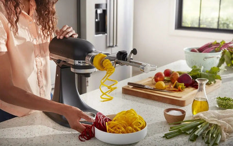 Woman using Fruit And Vegetable Spiralizer Attachment For Stand Mixer Power Hub With 5 Quick Change Blades to spiralize vegetables