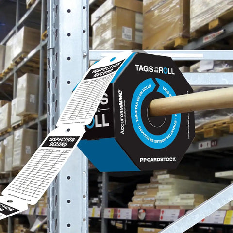 Flat Out Dependable Inspection And Status Record Tags By The Roll Including A Portable Octagon Dispenser and perforated tags in a warehouse.