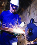 Odyssey II Eye Protection Goggles for Work worn by man grinding metal, anti fog, scratch resistant, latex free, blue frame.