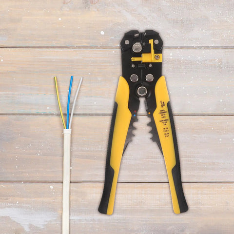Pro Grade Automatic Self Adjusting Wire Stripper And Crimping Pliers with black and yellow handles on wooden surface with wires.