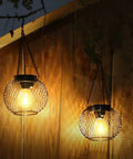 Auto On Solar Lanterns For Outdoors Upgraded Hanging Garden Lights Metal Waterproof Lanterns glowing at night on wood wall