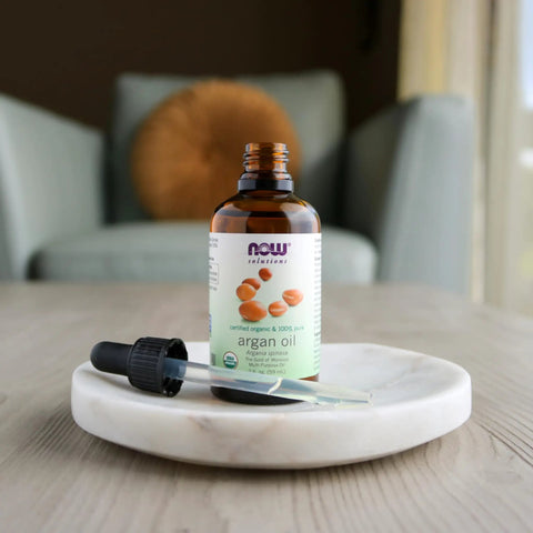 Gold of Morocco Organic Argan Oil 100 Percent Pure Multi Purpose Oil for Hair Skin Nails Hydration Shine Rich in Fatty Acids Certified Organic for All Skin Types 2 Ounce bottle on white dish with dropper