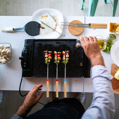 Preparing food with Long 32 Inch Telescoping Marshmallow Roasting Sticks For Fire Pit Smores Skewers Kit on a griddle
