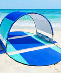 Beach Tent With Double Zippered Doors And Breathable Mesh For Two To Three People set up on sandy beach near ocean waves.