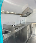 Interior view of Rollout Ready Custom Towable Food Trailer Commercial Mobile Catering Kitchen with stainless steel sinks and counter space.