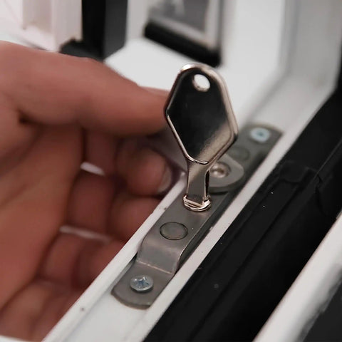 Heavy Duty Die Cast Metal Release Key That Works Like A Champ For Detachable Window Restrictor Stays And Replacement Hardware Tools With Smooth Mill Finish Look in use on a window restrictor.
